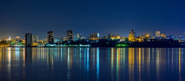 Amur Nehri 'nden Khabarovsk şehrinin Gece Manzarası. Mavi gece gökyüzü. Gece şehri fenerlerle parıldıyor..