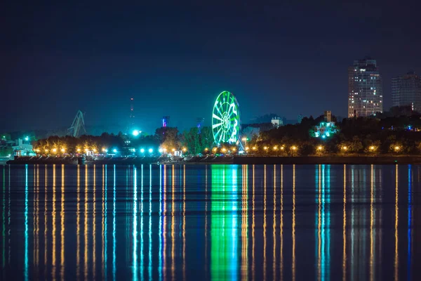 Vue de nuit de la ville de Khabarovsk depuis la rivière Amour. Ciel nocturne bleu. La ville nocturne est éclairée par des lanternes. — Photo