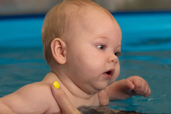 Nuoto infantile. Bambina che nuota in una piscina . — Foto Stock