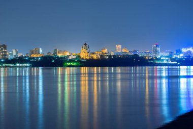 Amur Nehri 'nden Khabarovsk şehrinin Gece Manzarası. Mavi gece gökyüzü. Gece şehri fenerlerle parıldıyor..