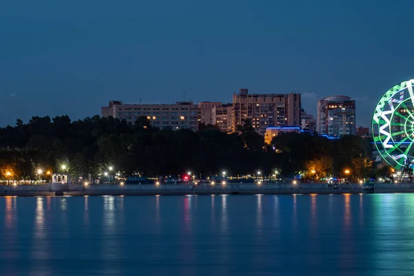 Vue de nuit de la ville de Khabarovsk depuis la rivière Amour. Ciel nocturne bleu. La ville nocturne est éclairée par des lanternes. — Photo