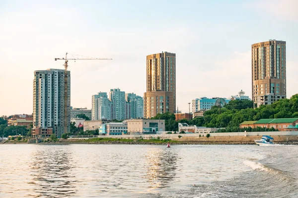 Vista de la ciudad de Jabárovsk desde el río Amur. Paisaje urbano por la noche al atardecer . — Foto de Stock