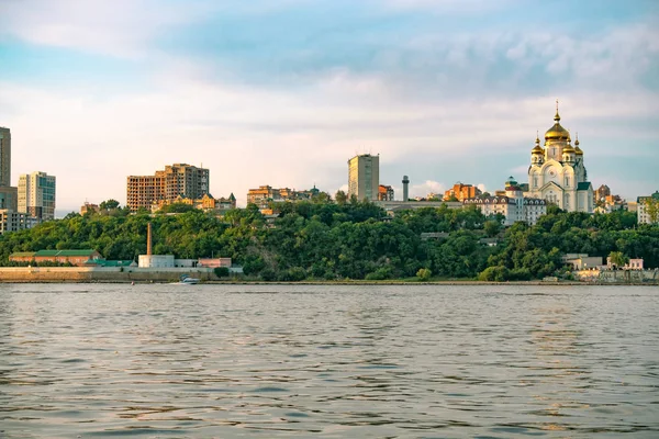 Vista de la ciudad de Jabárovsk desde el río Amur. Paisaje urbano por la noche al atardecer . — Foto de Stock