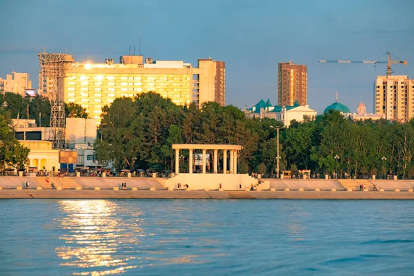 Uitzicht op de stad Khabarovsk vanaf de rivier de Amoer. Stedelijk landschap in de avond bij zonsondergang. — Stockfoto