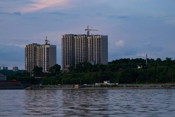 Jabárovsk, Rusia - 19 de julio de 2019: Vista de la ciudad de Jabárovsk desde el río Amur. Paisaje urbano por la noche al atardecer . — Foto de Stock