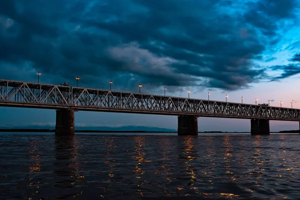 सूर्यास्ताच्या वेळी अमूर नदीवरील पूल. रशियाचा आहे. खाबरोव्हस्क. नदीच्या मध्यभागी फोटो . — स्टॉक फोटो, इमेज