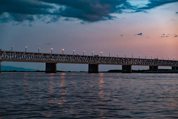 Puente sobre el río Amur al atardecer. Rusia. Khabarovsk. Foto del medio del río . — Foto de Stock