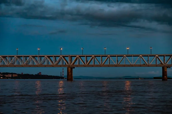 Ponte sul fiume Amur al tramonto. Russia. Khabarovsk. Foto dal centro del fiume . — Foto Stock