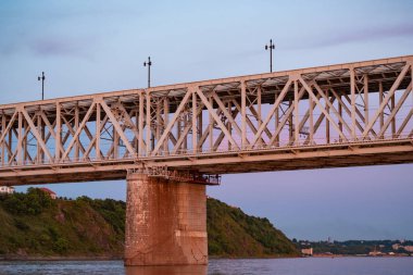 Gün batımında Amur nehri üzerinde köprü. Rusya. Khabarovsk. Nehrin ortasından fotoğraf.