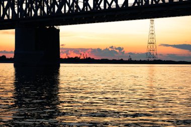 Gün batımında Amur nehri üzerinde köprü. Rusya. Khabarovsk. Nehrin ortasından fotoğraf.