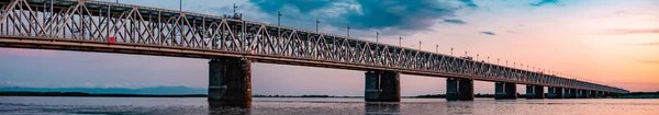 Gün batımında Amur nehri üzerinde köprü. Rusya. Khabarovsk. Nehrin ortasından fotoğraf.
