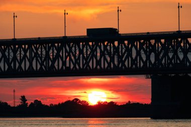Gün batımında Amur nehri üzerinde köprü. Rusya. Khabarovsk. Nehrin ortasından fotoğraf.