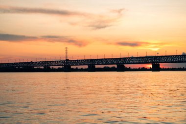 Gün batımında Amur nehri üzerinde köprü. Rusya. Khabarovsk. Nehrin ortasından fotoğraf.