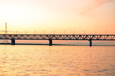 Gün batımında Amur nehri üzerinde köprü. Rusya. Khabarovsk. Nehrin ortasından fotoğraf.