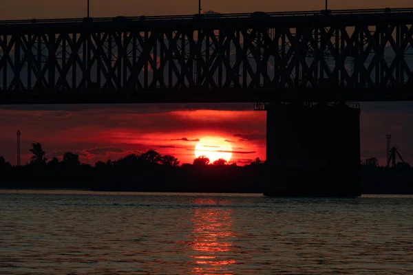 Brücke über den Amur bei Sonnenuntergang. Russland. Chabarowsk. Foto aus der Mitte des Flusses. — Stockfoto