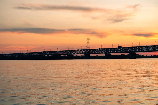 Γέφυρα πάνω από τον ποταμό Αμούρ το ηλιοβασίλεμα. Ρωσία. Χαμπάροφσκ. Φωτογραφία από τη μέση του ποταμού. — Φωτογραφία Αρχείου