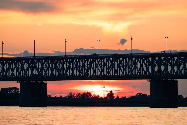Brücke über den Amur bei Sonnenuntergang. Russland. Chabarowsk. Foto aus der Mitte des Flusses. — Stockfoto