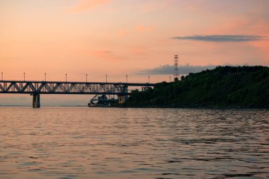 Gün batımında Amur nehri üzerinde köprü. Rusya. Khabarovsk. Nehrin ortasından fotoğraf.