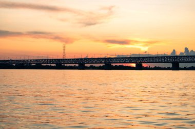 Gün batımında Amur nehri üzerinde köprü. Rusya. Khabarovsk. Nehrin ortasından fotoğraf.