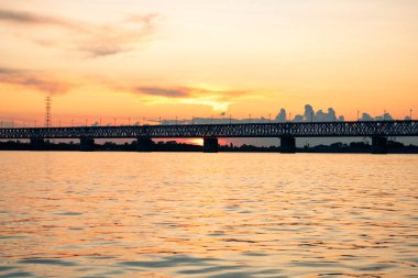 Gün batımında Amur nehri üzerinde köprü. Rusya. Khabarovsk. Nehrin ortasından fotoğraf.