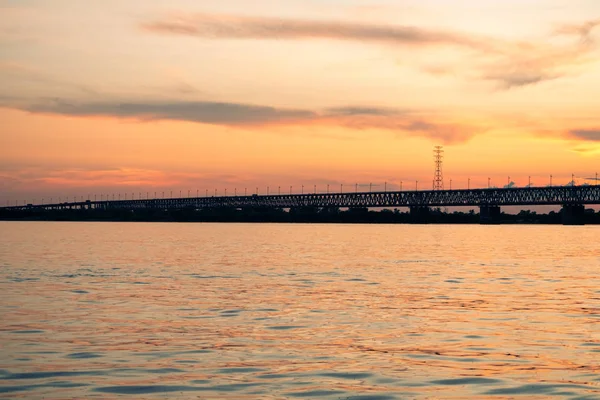 Brücke über den Amur bei Sonnenuntergang. Russland. Chabarowsk. Foto aus der Mitte des Flusses. — Stockfoto