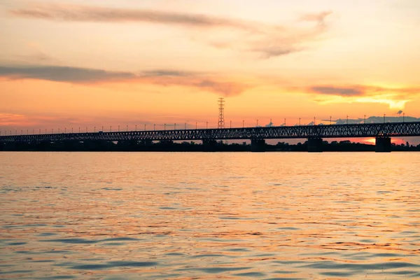 Brücke über den Amur bei Sonnenuntergang. Russland. Chabarowsk. Foto aus der Mitte des Flusses. — Stockfoto