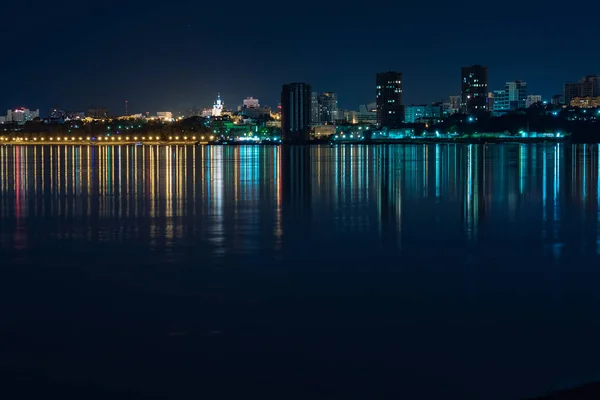 Night View of the city of Khabarovsk from the Amur river. Blue night sky. The night city is brightly lit with lanterns. The level of the Amur river at around 159 centimeters.