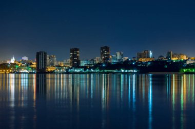 Amur nehrinden Habarovsk şehrinin gece manzarası. Mavi gece gökyüzü. Gece şehri fenerlerle aydınlıktır. Yaklaşık 159 santimetre de Amur nehri seviyesi.