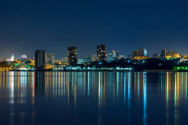 Vista noturna da cidade de Khabarovsk do rio Amur. Céu azul noturno. A cidade noturna é iluminada com lanternas. O nível do rio Amur em torno de 159 centímetros . — Fotografia de Stock