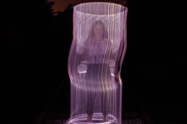 Donmuş ışıkla çevrili genç kız. Işıkla çizim. Uzun pozlama. Sanatsal soyutlama. Dondurucu ışık