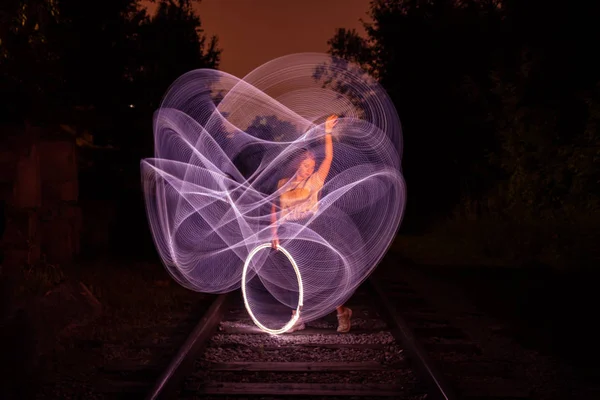 Young girl surrounded by frozen light. Drawing with light. Long exposure. Artistic abstraction. Freezelight — Stock Photo, Image