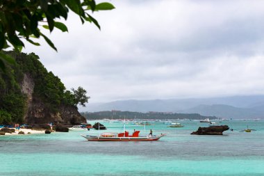 Boracay, Filipinler - 28 Ocak 2018: Diniwid plajı. Bulutlu havalarda plaj. Kıyıya yakın tekneler.