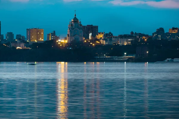 アムール川からハバロフスク市の夜景。青い夜空。夜市は明るく提灯で照らされています. — ストック写真