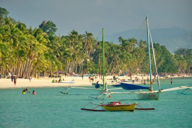 Boracay, Filipinler - 29 Ocak 2020 Boracay adasının beyaz plajı. Turistler plaj boyunca yürür ve denizde yüzerler. Coronavirüs salgınından birkaç gün önce.