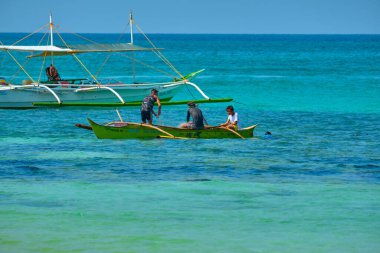 Boracay, Filipinler - 20 Ocak 2020: Gündüz vakti Boracay adasının boş beyaz plajı. Koronavirüs yüzünden Çinli turist yok. Yerel halk tekneden balık yakalar.