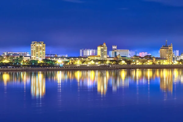 Blagoveshchensk, Rusya - 25 Haziran 2020: Blagoveshchensk şehrinin setinden Çin 'in Heihe şehrine bakış. Gecenin ışıkları Amur nehrinin yansımasında.