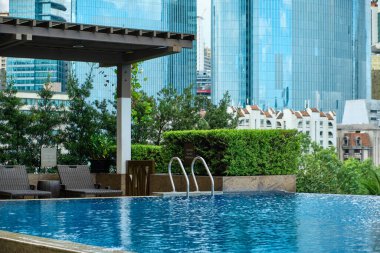 Manila, Filipinler - Şubat 02, 2020. Manila şehrinin beş yıldızlı lüks Discovery Primea otelinin havuzundan görünüşü. Güneşli bir hava. Arka planda gökdelenler.