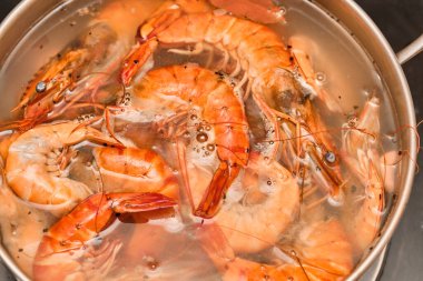 Kırmızı karidesler metal bir tencerede pişirilir..