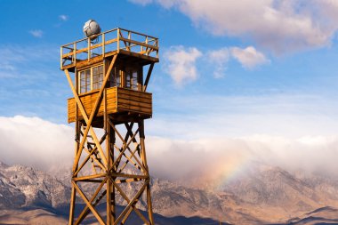 Bir gökkuşağı Manzanar Nöbetçi kulesinde arkasında Sierra Nevada dağlarında oluşuyor