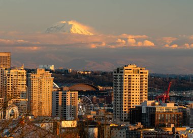 Göstermek ve mesafe Seattle Washington bir kısmını arkasında parlayan Rainier Dağı tepesinde bulutların izin