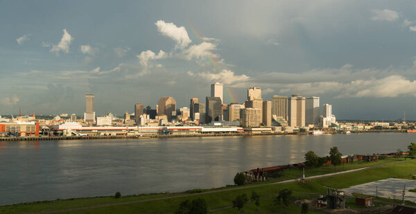 Река Миссисипи течёт вдоль береговой линии Нового Орлеана, освещая радугу.
