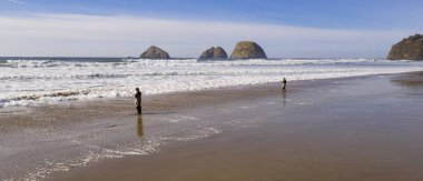 Okyanusta Balık tutma iki adam Oceanside Oregon Pasifik üzerinde sörf.