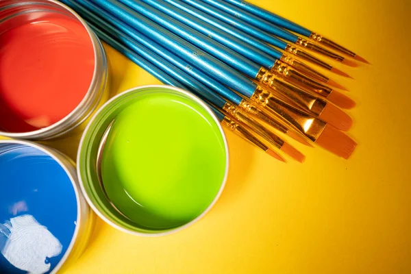 Red Green Blue Paint Cans Yellow Background Brushes — Stock Photo, Image