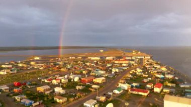 Gecenin bir yarısı Kotzebue Alaska 'da güneş doğarken yağmur yağar ve güneş ile fırtına arasında güzel bir kontrast yaratır.