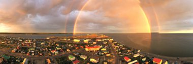 Gecenin bir yarısı Kotzebue Alaska 'da güneş doğarken yağmur yağar ve güneş ile fırtına arasında güzel bir kontrast yaratır.