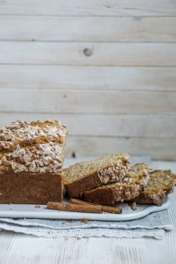 Beyaz ahşap arka plan bazı ayrıntılar tarçın ve kumaş ile yakın kadar seçici odak üzerine tarçın kırıntı ceket ile organik muz ekmek ev yapımı