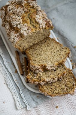 Beyaz ahşap arka plan bazı ayrıntılar tarçın ve kumaş ile yakın kadar seçici odak üzerine tarçın kırıntı ceket ile organik muz ekmek ev yapımı