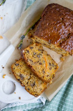 Havuç somun kek parlak sırlı ve Beyaz ahşap zemin üzerinde fındık ile yakın kadar seçici odak