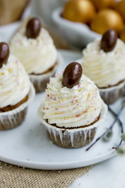 Cupcakr de Pâques carotte avec oeuf en chocolat sur le dessus et crème fouettée glaçage gros plan seective focus Photos De Stock Libres De Droits