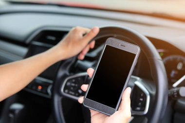 Araba kullanırken telefonu kullanan genç adam.